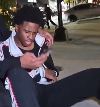 Nitro Camden checking his phone while seated during a nighttime IRL stream.