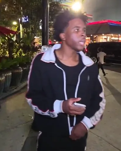 Nitro Camden standing with his phone during a nighttime IRL stream.