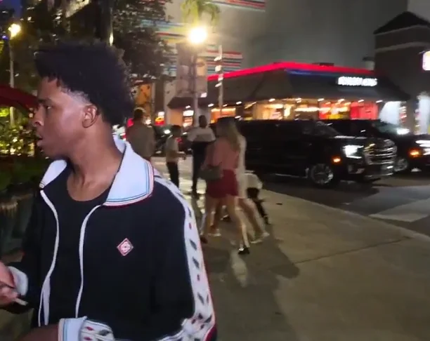 Nitro Camden walking along a lit city sidewalk during a nighttime IRL stream.
