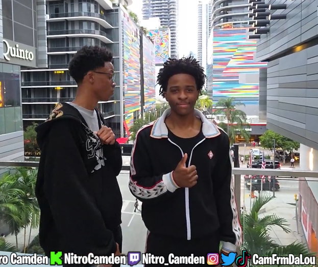 Nitro Camden beside another person on an outdoor city walkway during an IRL stream.